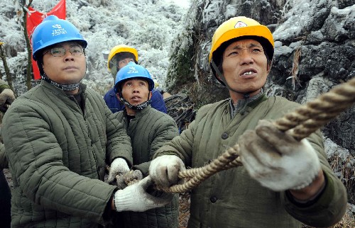 2月2日,在贵阳市图云关的一条因雪凝灾害造成的110千伏输电线路的损毁现场,南方电网公司贵州送变电的抢险人员正在架最后一相电。 新华社记者 杨楹 摄