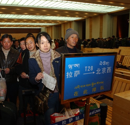 1月8日,乘客在拉萨火车站准备上车。 春节临近,西藏拉萨火车站开始出现客运高峰。据铁路部门的消息,目前出站旅客以返乡的打工者和到拉萨朝拜的藏民为主。 新华社记者 杨光 摄