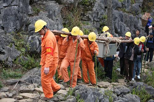1月28日,电网工人在广西河池市大化县大石山区将变电器运进村屯。为确保春节期间电力可靠供应,解决农网用电“卡脖子”问题,南方电网广西电网公司近日启动农网重过载台区改造升级工作,采取“大换中、中换小”轮换变压器的工作模式,重点解决农村春节期间的用电问题,让农民朋友过上一个亮堂春节。 新华社发(潘方强 摄)