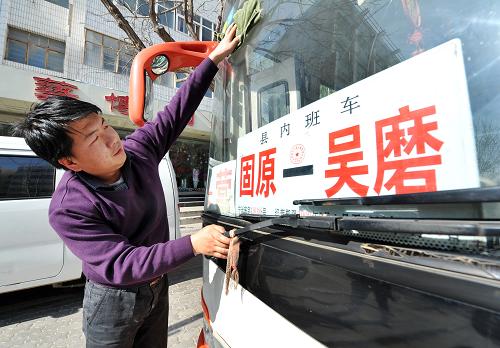 1月30日,司机师傅在发车前擦洗车窗玻璃。这是一辆从宁夏固原市市区开往彭堡镇吴磨村的城乡班车。一年一度的春运开始后,在宁夏西海固地区固原市原州区,一趟趟行驶在农村公路上的公交车迎来客运高峰。春运期间,仅固原市原州区每天就有600余个班次的农村公交车往返行驶,每天都要为12000多位乘客服务。在一趟从市区到彭堡镇吴磨村的城乡公交车上,记者了解到,这趟车途经6个村庄,20多个停靠点。“现在大部分都是回村里过节的人,还有进城买年货的。”售票员一边售票一边告诉记者。整个行程大约30公里左右,票价也从1元到5元不等。班车途经头营镇后,大部分乘客都陆续下车了,班车也没有急着走。“在流量比较大的站点要多等一会儿,因为错过这一班,就要等很久了。”售票员一边喝水一边说:“很多人都是靠着我们这班车赶回家过年的。”新华社记者 彭昭之 摄