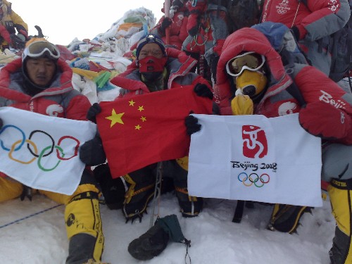 5月8日,北京奥运圣火珠峰传递登山队成功登顶珠峰。这是登山队员在峰顶展示中国国旗、奥运五环旗和北京奥运会会徽旗。 新华社特约记者阿旺扎西摄