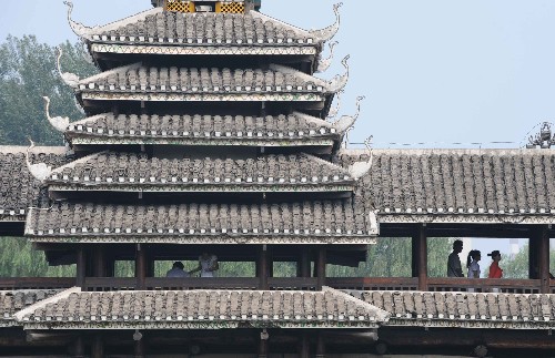 7月26日,游客在北京中华民族园侗族风雨楼参观。新华社记者 武巍 摄