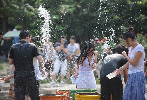 7月26日,游客在北京中华民族园傣族景区体验傣族的泼水节。新华社记者 武巍 摄