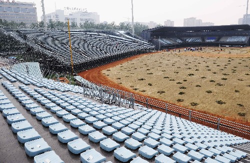 北京五棵松体育中心棒球场,是北京奥运会的临建场馆之一,届时奥运会棒球比赛将在这里举行。“省”字当头是棒球场的一大特色,场地的设计兼顾了赛时功能和赛后的拆除和利用。外围幕墙采用金属网结构,适合藤蔓植物的攀爬,既保证了外在美观,也确保了场内采光等功能需求。同样是出于节俭的考虑,五棵松棒球场的看台采用两种方式完成,下部有功能用房的看台部分采用钢结构设计,顶部为支膜结构的罩棚,其余部分的看台,则会在奥运会比赛的时候临时租用或搭建支撑型活动看台,这样就可以为场地的赛后运行减少固定的负担,节省了建设成本。 这是五棵松棒球场的临时看台(5月16日摄)。新华社记者 王颂 摄