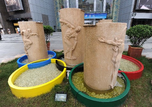 青岛市区一家商厦前的奥运主题雕塑(7月28日摄)。 新华社记者 宋振平 摄