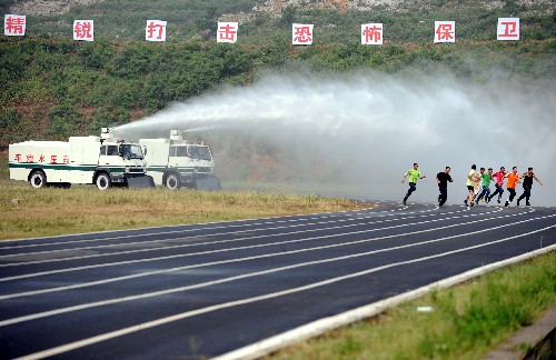 7月2日,武警战士在演示用高压水炮车冲散扰乱人群。 当日,武警山东省总队在训练基地举行奥运安保反恐新装备演示,旨在检验武警部队在奥运会期间防范、处置恐怖袭击事件的应急反应能力。 新华社记者 范长国摄