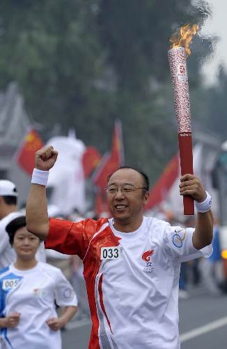 8月6日,火炬手孟令迪手持火炬传递。当日,北京奥运圣火在北京市传递。 新华社记者戚恒摄