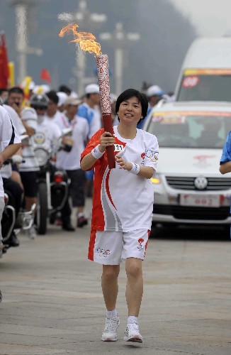 8月6日,火炬手宋鱼水手持火炬传递。当日,北京奥运圣火在北京市传递。 新华社记者戚恒摄