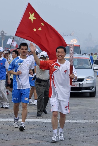 8月6日,火炬手肖钢手持火炬传递。当日,北京奥运圣火在北京市传递。 新华社记者戚恒摄