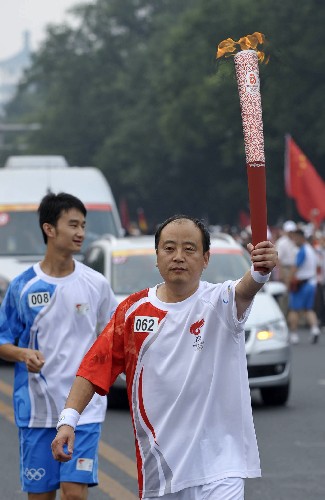 8月6日,火炬手张宝海手持火炬传递。当日,北京奥运圣火在北京市传递。 新华社记者戚恒摄