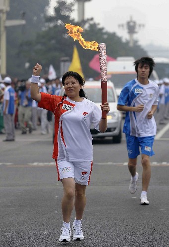 8月6日,火炬手赵晓霞手持火炬传递。当日,北京奥运圣火在北京市传递。 新华社记者戚恒摄