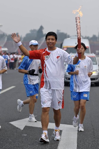 8月6日,火炬手鲁向东手持火炬传递。当日,北京奥运圣火在北京市传递。 新华社记者戚恒摄