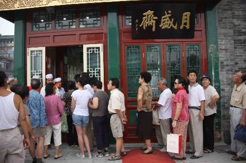 8月7日,顾客在前门大街一老字号门前排队购物。当日,北京前门大街正式开街。北京前门大街北起前门月亮湾,南至珠市口,全长840米。自2007年5月9日开始,前门大街开始了大规模修缮整治工程。此前的几年里,修缮方案共经过了16位文物专家32次专业论证。 新华社记者张燕辉摄