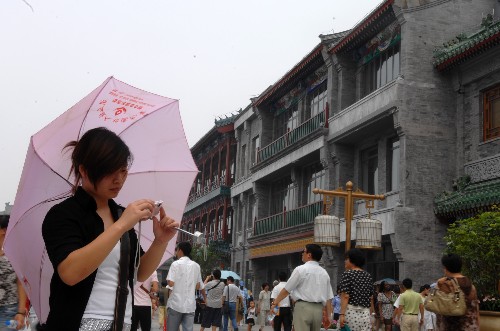 8月7日,一位女孩在前门大街拍照留念。当日,北京前门大街正式开街。北京前门大街北起前门月亮湾,南至珠市口,全长840米。自2007年5月9日开始,前门大街开始了大规模修缮整治工程。此前的几年里,修缮方案共经过了16位文物专家32次专业论证。 新华社记者金良快摄