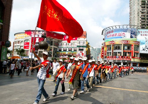 8月1日,广州市荔湾区的奥运安保志愿者行动队在上下九商业区中前行。