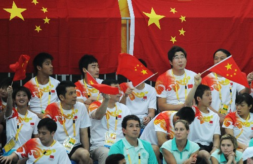 8月10日,中国跳水队队员在观众席上为队友郭晶晶/吴敏霞助威。