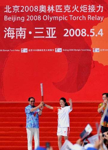 5月4日,海南省省委书记卫留成(左)将火炬交给第一棒火炬手杨扬。当日,北京奥运会圣火传递活动在中国海南三亚举行。 新华社记者 姜恩宇 摄