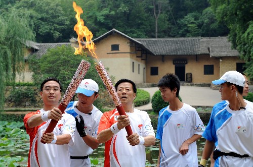6月5日,在毛泽东故居前,火炬手毛雨时(在三)与下一棒火炬手谢振华交接。当日,北京奥运圣火在湖南韶山传递。 新华社记者赵众志 摄