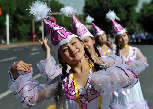 6月17日,一些中学生在表演柯尔克孜族舞蹈欢迎奥运圣火的到来。当日,北京奥运圣火在新疆乌鲁木齐传递。 新华社记者 赵戈 摄