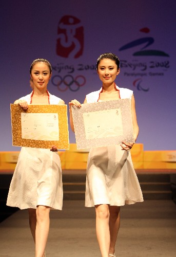 7月17日,模特展示北京奥运会运动员获奖证书。当日,北京2008年奥运会颁奖礼仪服饰及主要颁奖元素发布会在北京“798”艺术区举行,发布了奥运会颁奖专业志愿者将在颁奖仪式上穿着的礼服和礼仪用鞋,同时发布了颁奖台、颁奖花束、运动员获奖证书等主要颁奖元素。 新华社记者 孟永民 摄