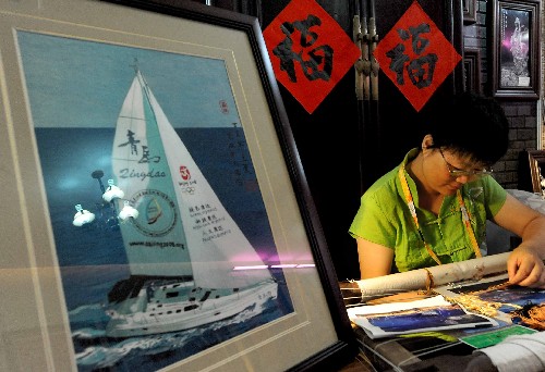 在青岛奥运村中国民俗展的展区内,一位刺绣艺人在现场制作绣品(7月27日摄)。 新华社记者 王颂 摄