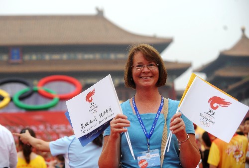 8月6日,一名来自美国加利福尼亚州的游客在北京故宫午门前手举小旗为北京奥运加油。当日,北京奥运圣火在北京市传递。 新华社记者 罗晓光 摄