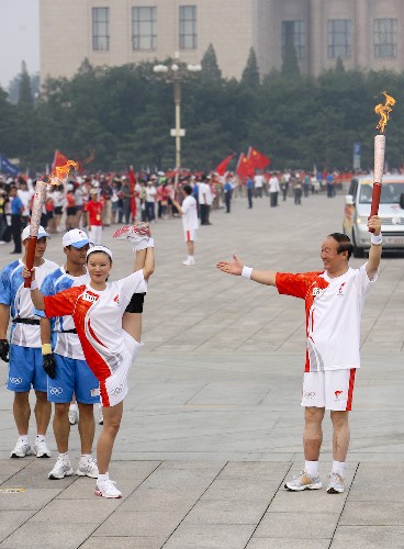 8月6日,火炬手、北京奥组委执行副主席蒋效愚(右)与下一棒火炬手邓敏交接后合影。当日,北京奥运圣火在北京市传递。 新华社记者 邢广利 摄