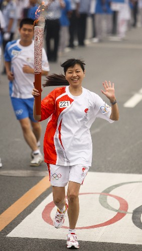 8月6日,火炬手周继红手持火炬传递。当日,北京奥运圣火在北京市传递。 新华社记者 邢广利 摄