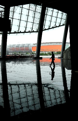 提到沈阳,关心体育、关注足球的人自然会想到五里河体育场。2001年10月7日,正是在这里,中国足球冲击世界杯成功,圆了足球人44年的梦。2006年3月,在“老五里河”东南3公里处,沈阳奥体中心新五里河体育场破土动工,仅仅15个月后,一座外形为“水晶皇冠”的宏伟体育场交付使用。从2008年8月6日开始,新五里河体育场将迎来建成后最为重要的赛事,北京奥运会足球比赛,8月6日到16日,12场奥运会足球比赛将在这里进行,而中国男足国奥队也将在新五里河努力寻找7年前的辉煌。 图为一名工作人员从沈阳奥体中心五里河体育场的二层通道区内走过(摄于7月22日)。 新华社记者谢环驰摄