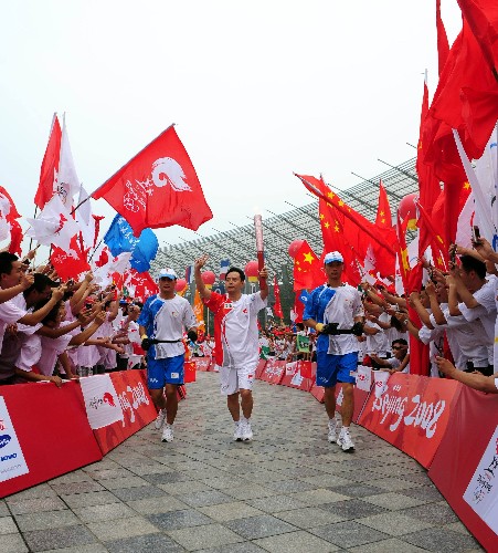 8月5日,火炬手余志荣手持火炬传递。当日,北京奥运圣火在四川省成都市传递。 新华社记者刘力航摄