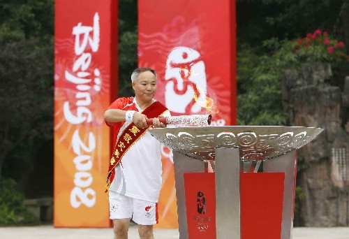 8月4日,最后一棒火炬手抗震救灾英模代表、汶川县映秀小学教师谭国强点燃圣火盆。当日,北京奥运圣火在四川省乐山市传递。 新华社记者 鲁金博 摄