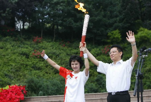 8月4日,第一棒火炬手高敏(左)与乐山市委书记姜晓亭共同高举火炬。当日,北京奥运圣火在四川省乐山市传递。 新华社记者鲁金博摄