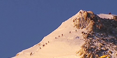 5月8日清晨,登山队员在金色的阳光中向峰顶冲击(视频截图)。当日凌晨,北京奥运圣火珠峰传递登山队从海拔8300米的突击营地出发,向着珠峰峰顶冲击。目前,登山队已接近峰顶。新华社发