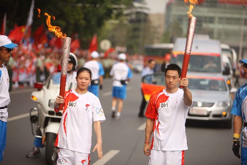 5月31日,第一棒火炬手杨威(右)与第二棒火炬手程菲展示火炬。当日,北京奥运圣火在湖北武汉传递。 新华社记者邢广利摄