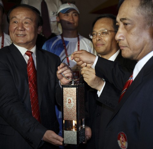 4月22日,在印度尼西亚首都雅加达,北京奥组委执行副主席蒋效愚(左)、中国驻印度尼西亚大使兰立俊(中)和印尼奥委会副主席亨达尔基手持火种灯合影。当日凌晨,北京奥运圣火抵达印度尼西亚首都雅加达。新华社记者 张军 摄