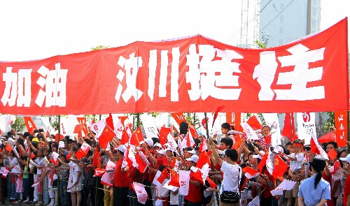 5月16日,当地群众在观看圣火传递时打出“汶川挺住”的横幅。当日,北京奥运圣火传递活动在江西南昌举行。 新华社记者邢广利摄