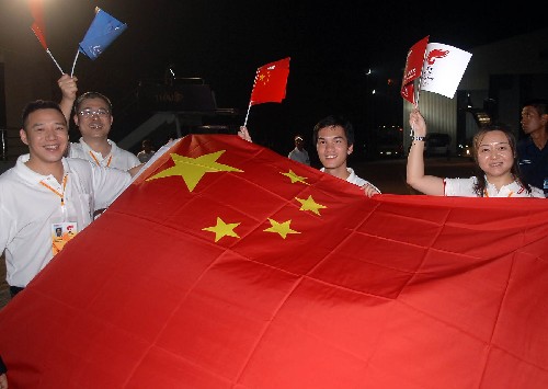4月18日,中国使馆工作人员手举国旗迎接奥运圣火的到来。新华社记者 公磊 摄