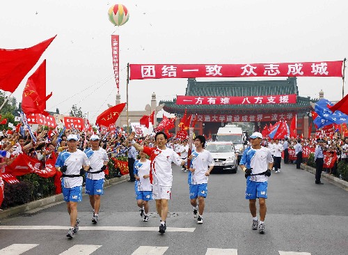 5月24日,火炬手张杰手持火炬传递。当日,北京奥运会圣火继续在上海传递。 新华社记者凡军摄