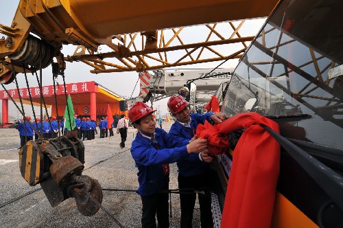 4月18日,参加京沪高速铁路开工典礼的工人师傅在施工车上系大红花。新华社记者 何俊昌 摄