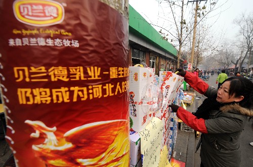 12月11日,在石家庄市革新东街市场,一家奶制品专卖店的销售商正在整理奶制品。近日,曾是三鹿集团最大液态奶生产基地的邢台三鹿乳业有限公司正式更名为河北贝兰德乳业有限公司,“贝兰德”牌百利包纯牛奶、大红枣牛奶、麦香牛奶及酸酸乳饮料等系列产品陆续上市。据介绍,目前产品已经在河北省石家庄、保定等6个地市和河南安阳恢复市场供应,日销售量达到40吨左右。新华社记者 巩志宏 摄