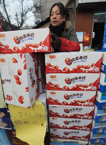12月11日,在石家庄市革新东街市场,一名奶制品销售商正在搬运贝兰德大红枣牛奶。新华社记者 巩志宏 摄