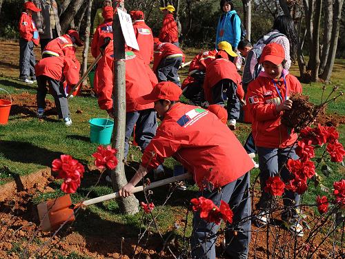1月5日,来自四川地震灾区安县的小学生在云南昆明世博园植树。 新华社记者 蔺以光 摄